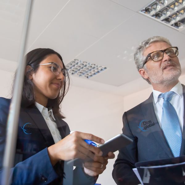 ejecutivo y ejecutiva revisando el pizarron